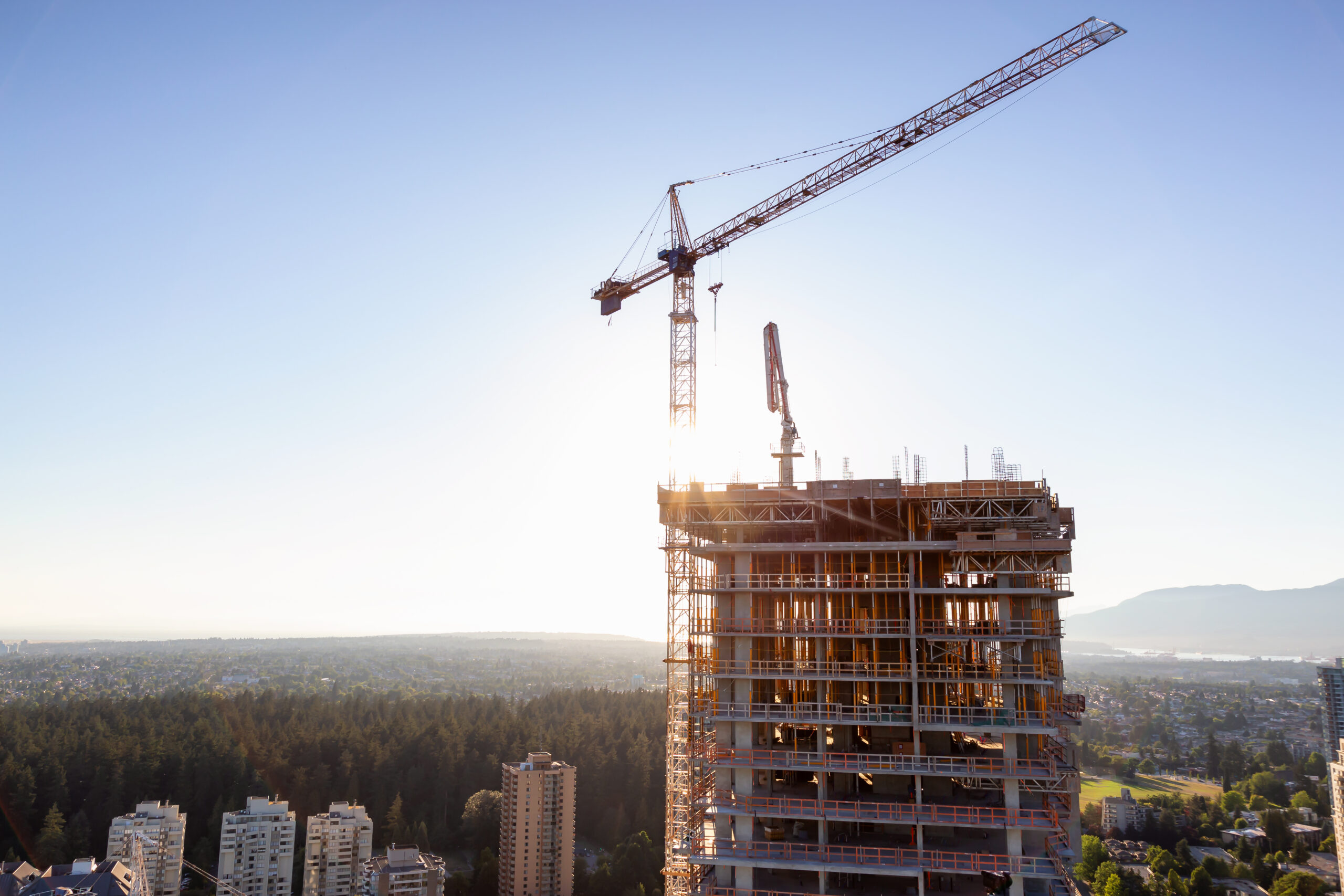 Aerial view of a residential building construction site during a vibrant summer sunset. Taken in Burnaby, Vancouver, BC, Canada.